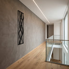 Framed Abstract Waves Vertical Metal Wall Art, side view in a modern hallway